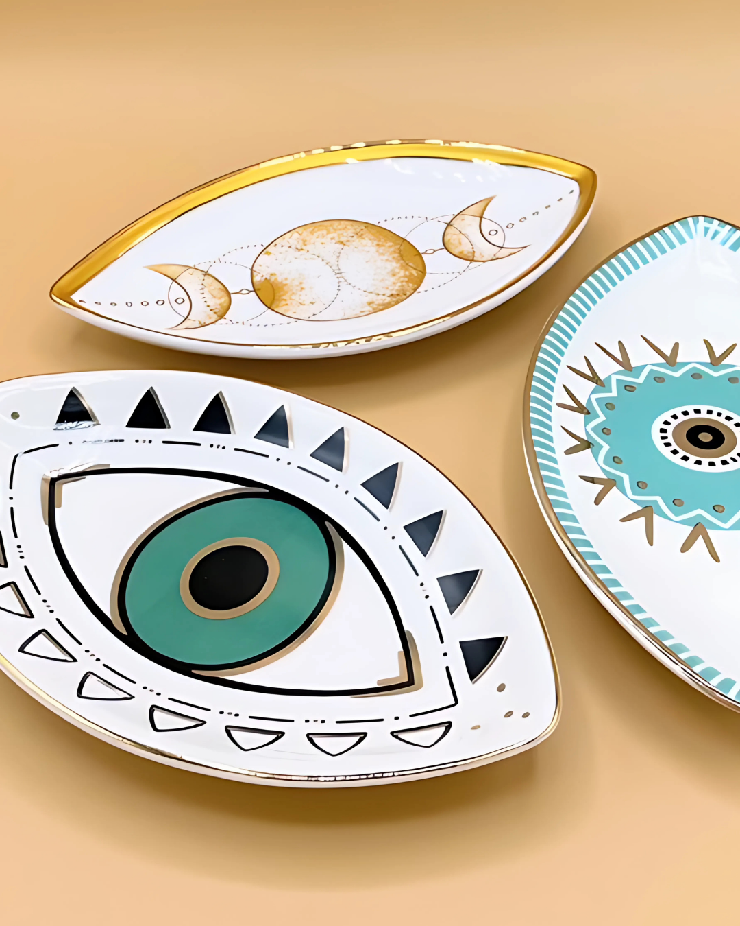 Three decorative plates with eye designs on a beige background