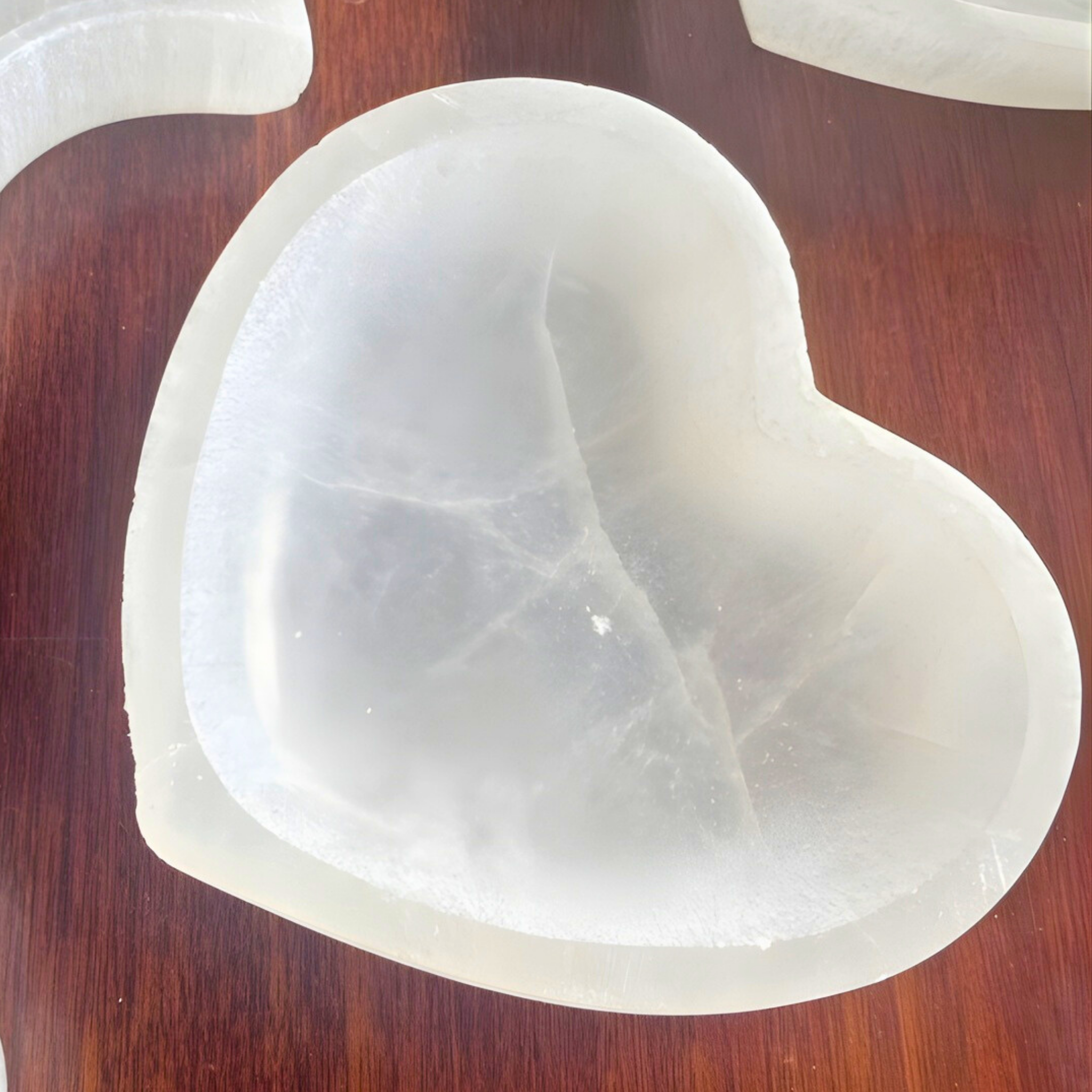 Heart-shaped white stone bowl on a wooden surface
