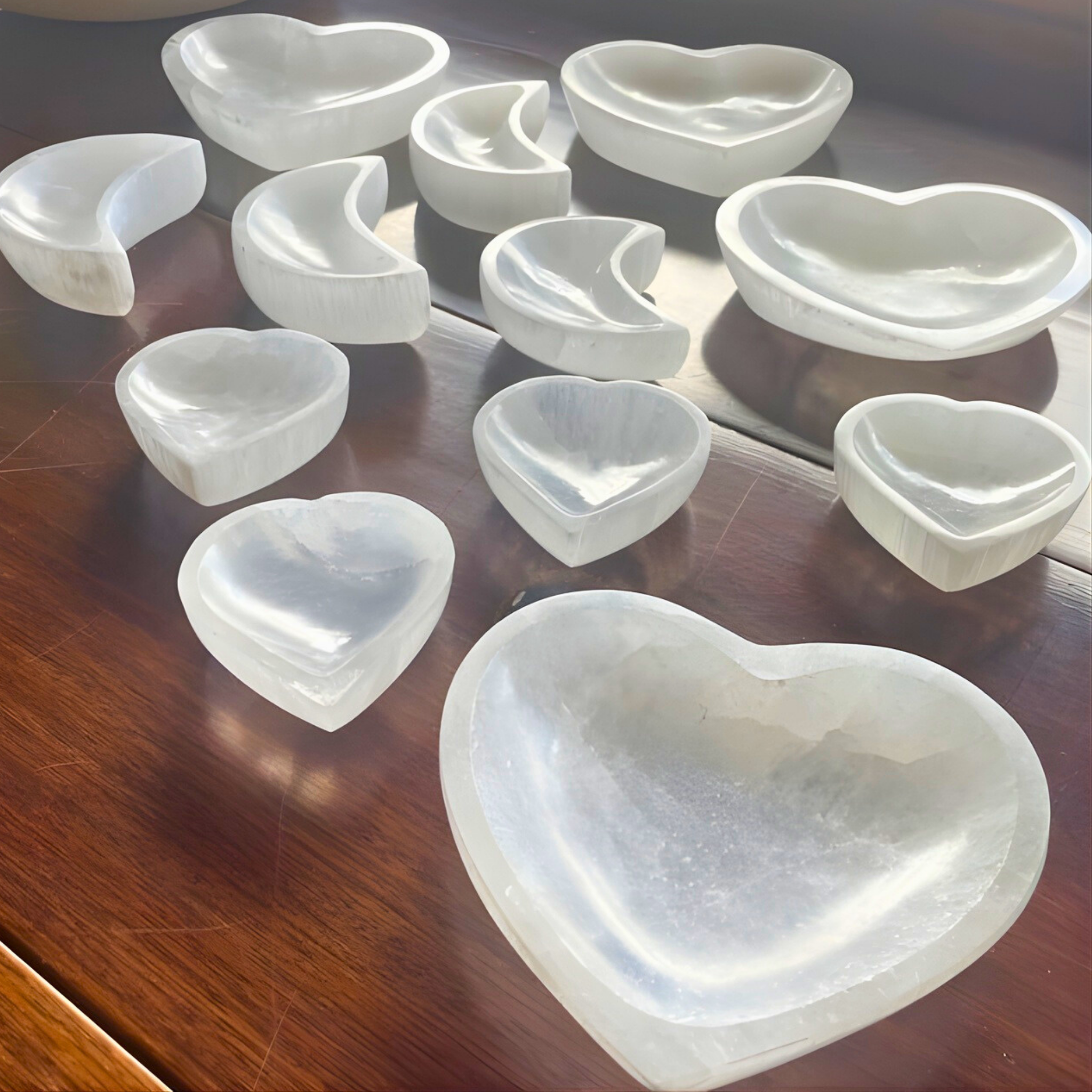 Set of heart-shaped white ceramic dishes on a wooden surface