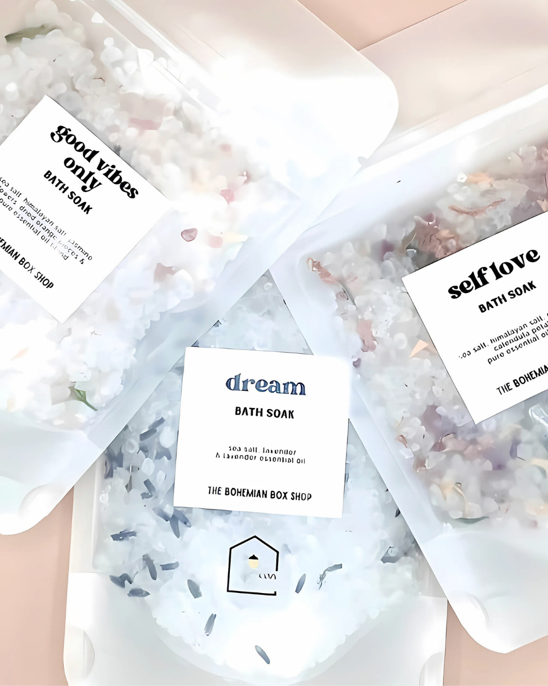 Bath soaks with labeled ingredients on a light pink background