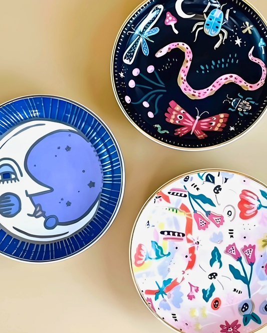 Three decorative plates with unique designs on a beige background