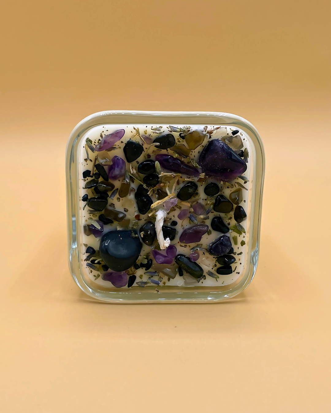 Glass container with decorative stones on a beige background