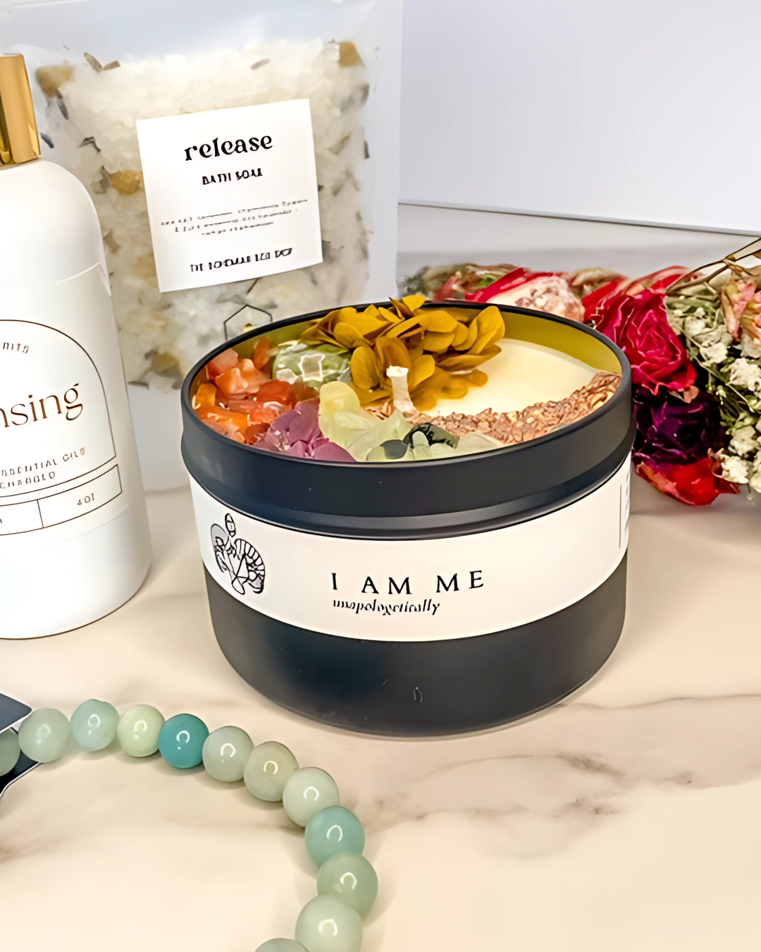 Bowl of colorful bath bombs with 'I AM ME' branding on a marble surface.