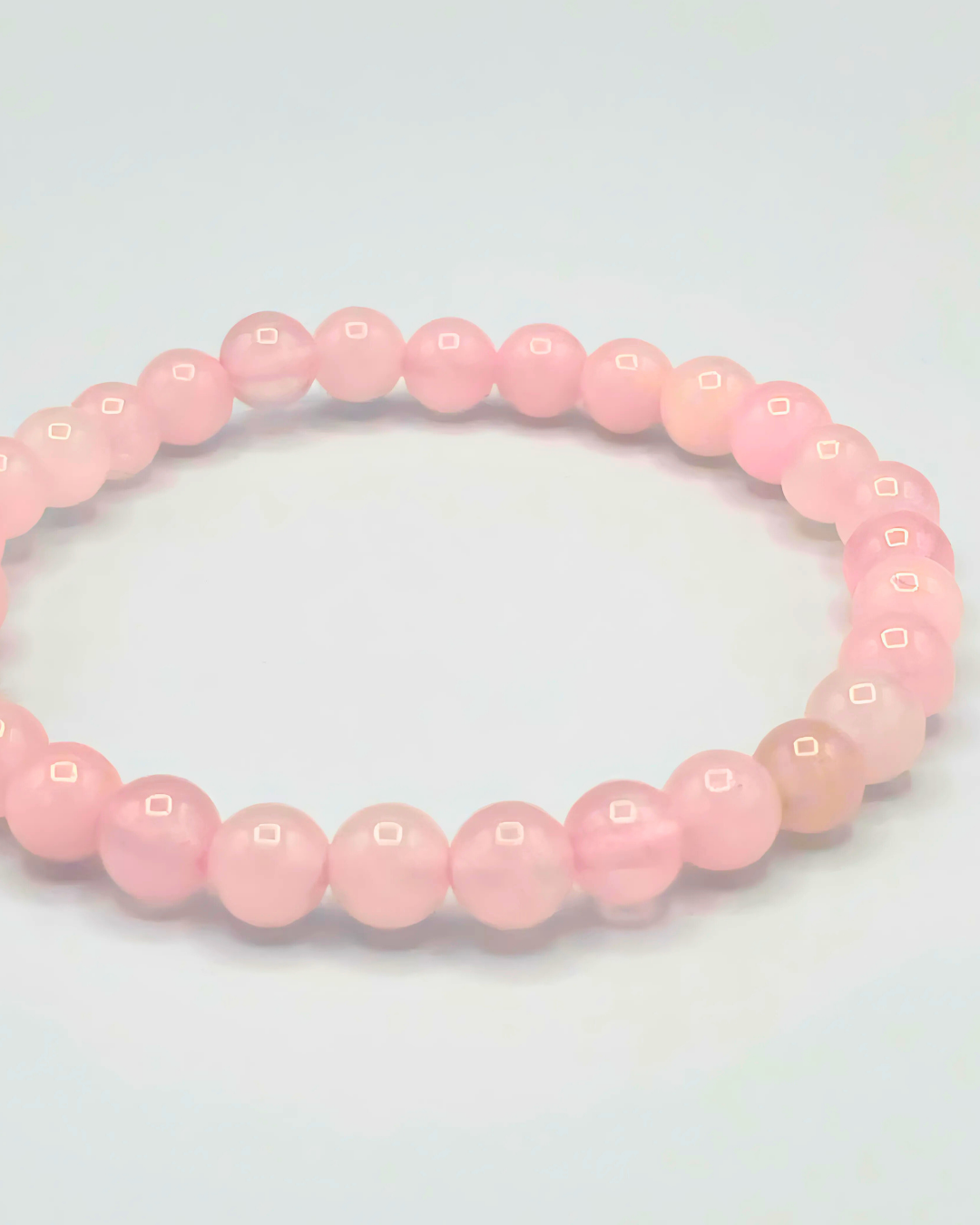 Pink beaded bracelet on a light gray background