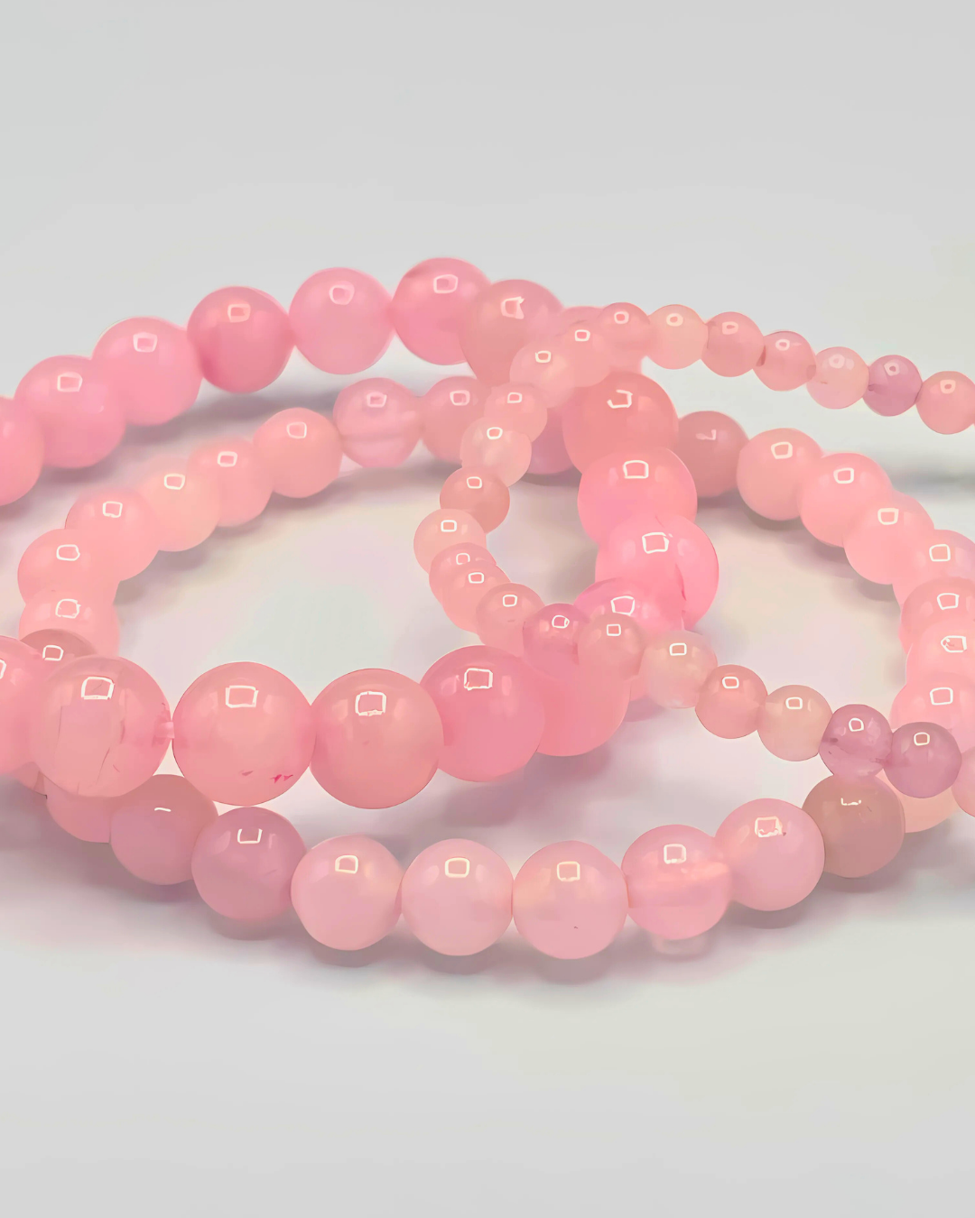Pink beaded bracelets on a light gray background