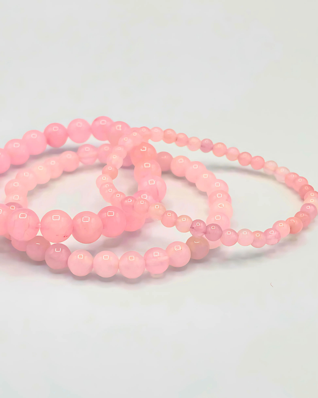 Pink beaded bracelets on a light gray background
