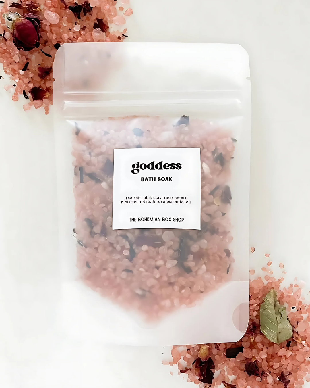 Pink bath salt package with dried herbs and a 'Goddess Bath Soak' label on a white background.