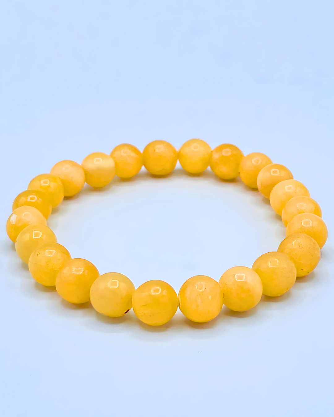 Yellow beaded bracelet on a light blue background