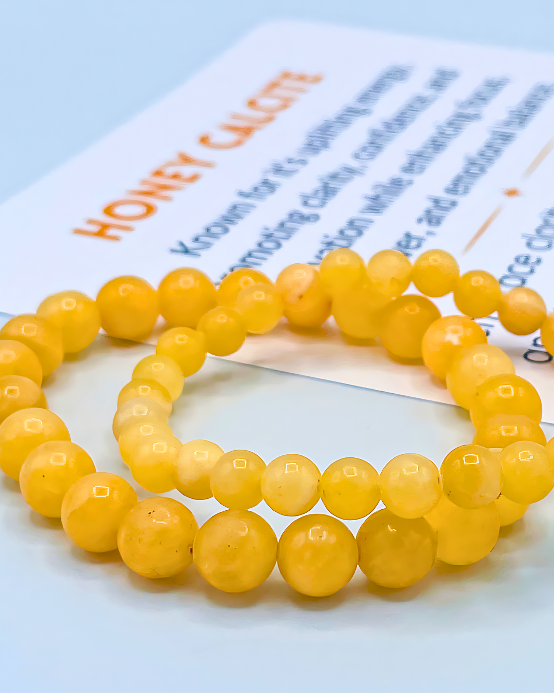Two yellow beaded bracelets on a light blue background with text overlay.