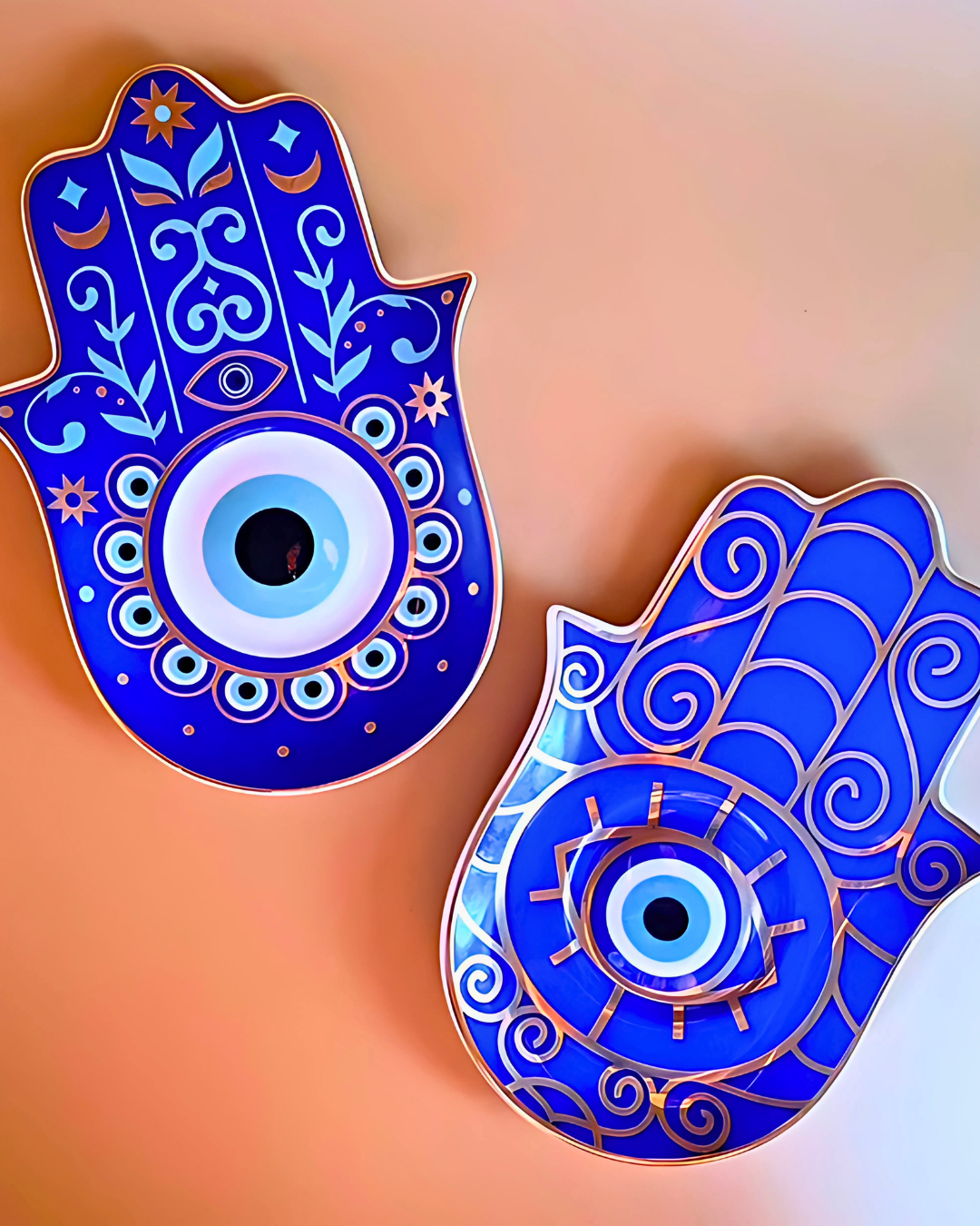 Two blue Hamsa hand designs with eye symbol on a gradient background
