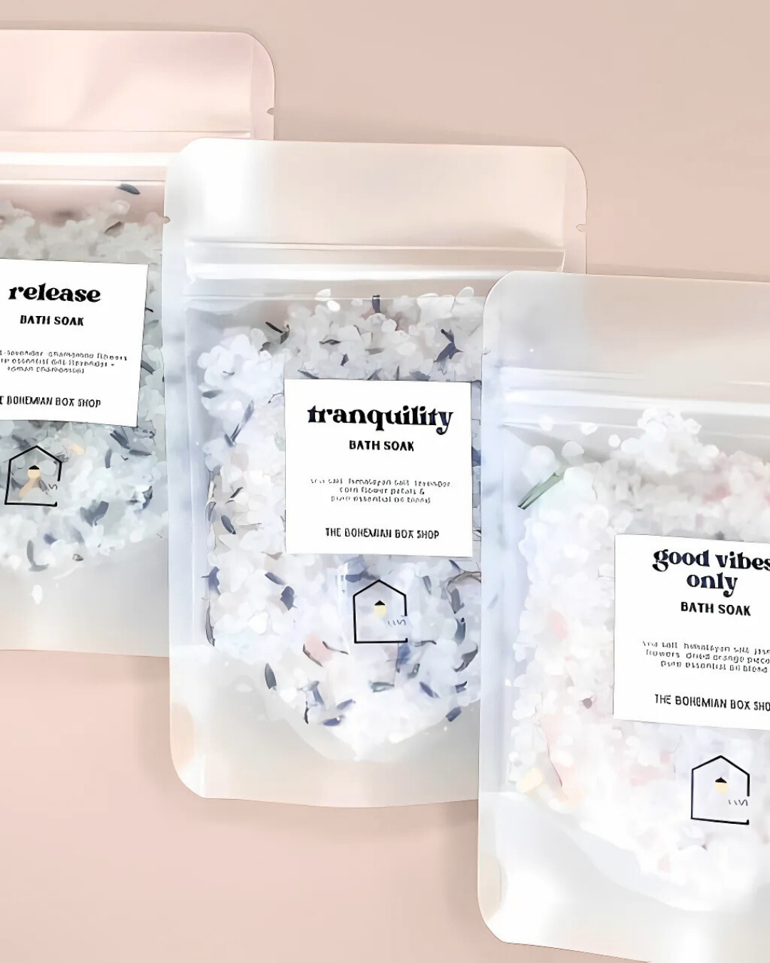 Three bath soaks with labels on a pink background