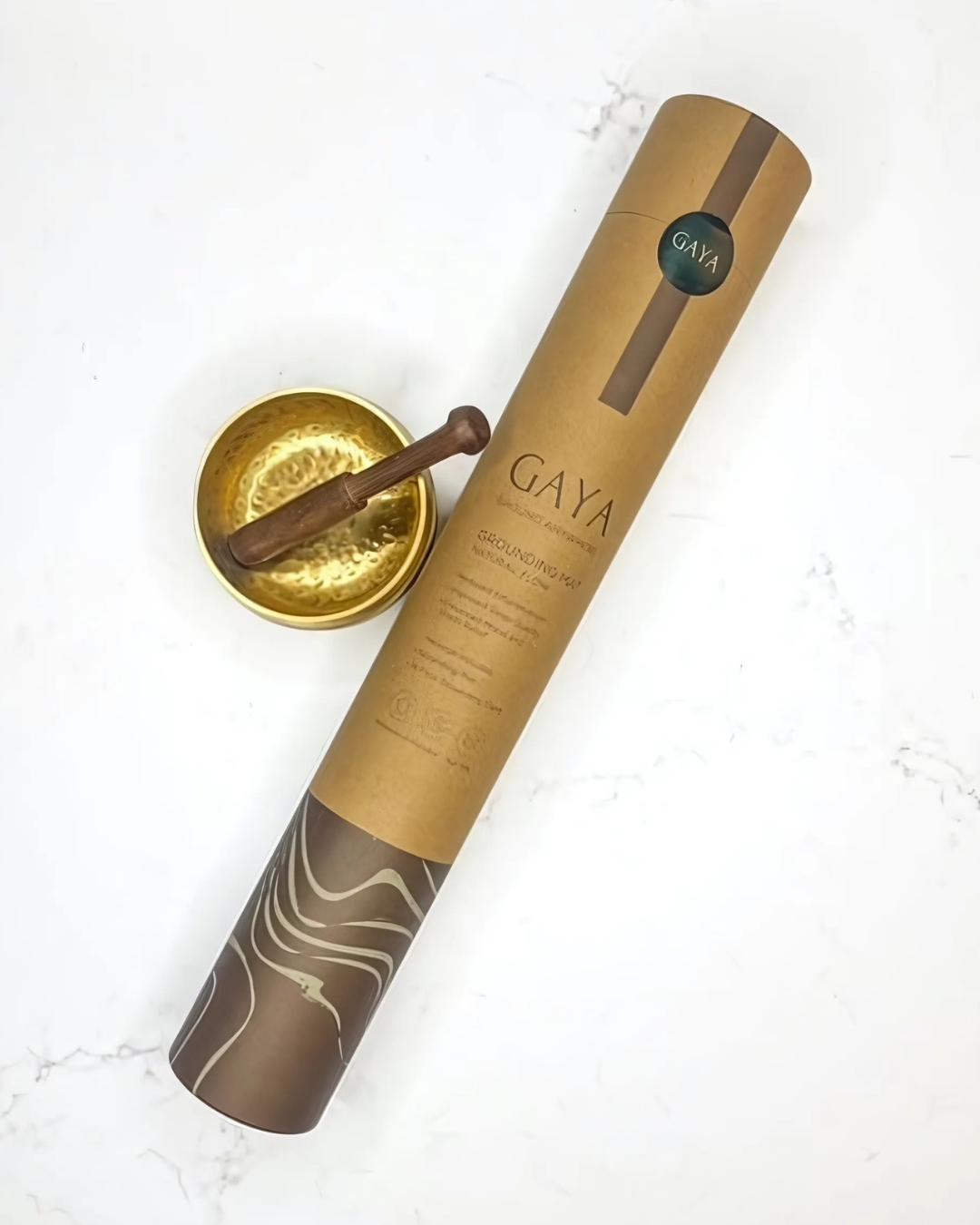 Gaya hair care product with a gold bowl and wooden tool on a white background