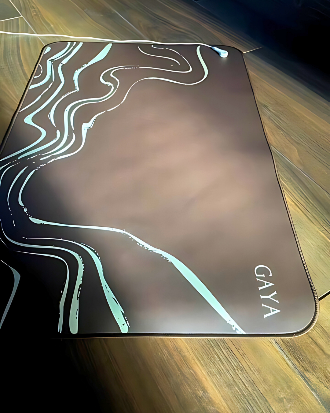 GAYA mouse pad with abstract design on a wooden surface