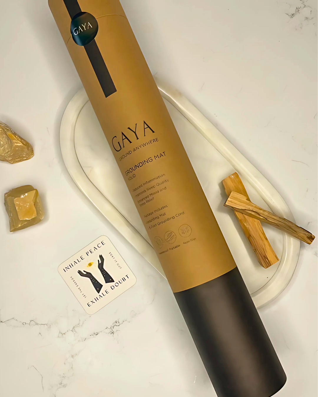 Gaya hair product on a marble surface with palm leaves and a card.