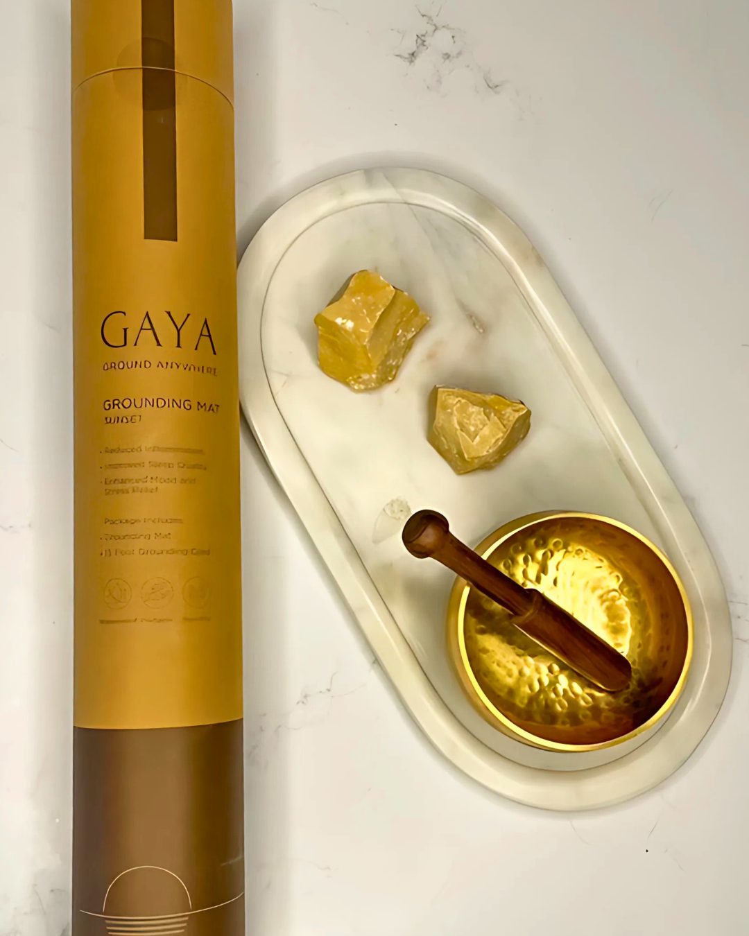 GAYA grounding balm with a marble tray containing balm and a wooden spoon on a light background