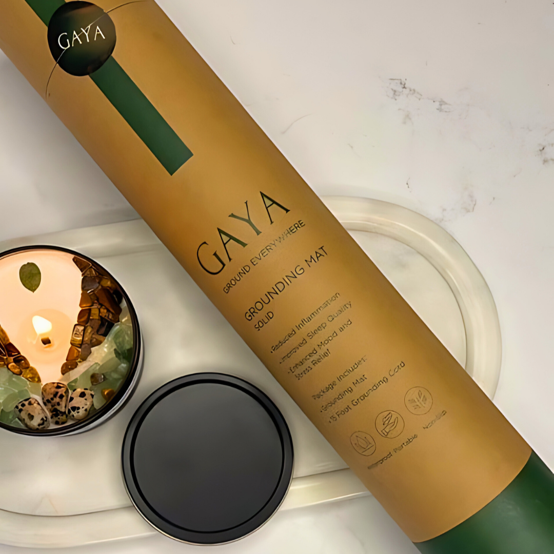 Gaya Grounding Mat packaging with a candle on a white surface