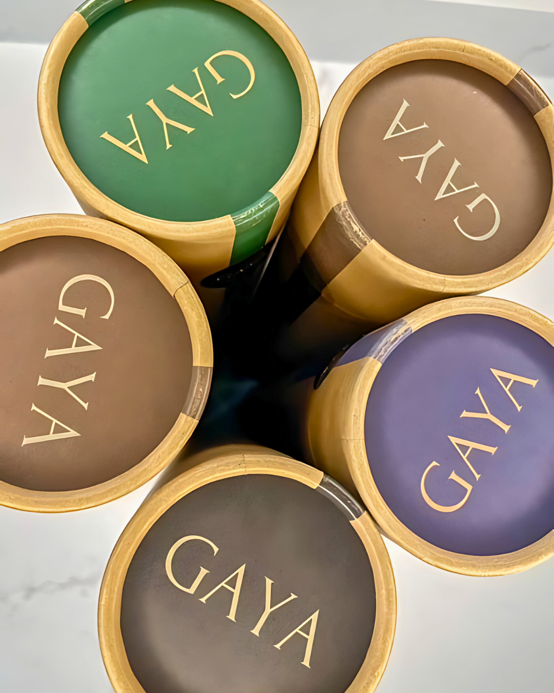 Five GAYA cosmetic containers in different colors on a light background