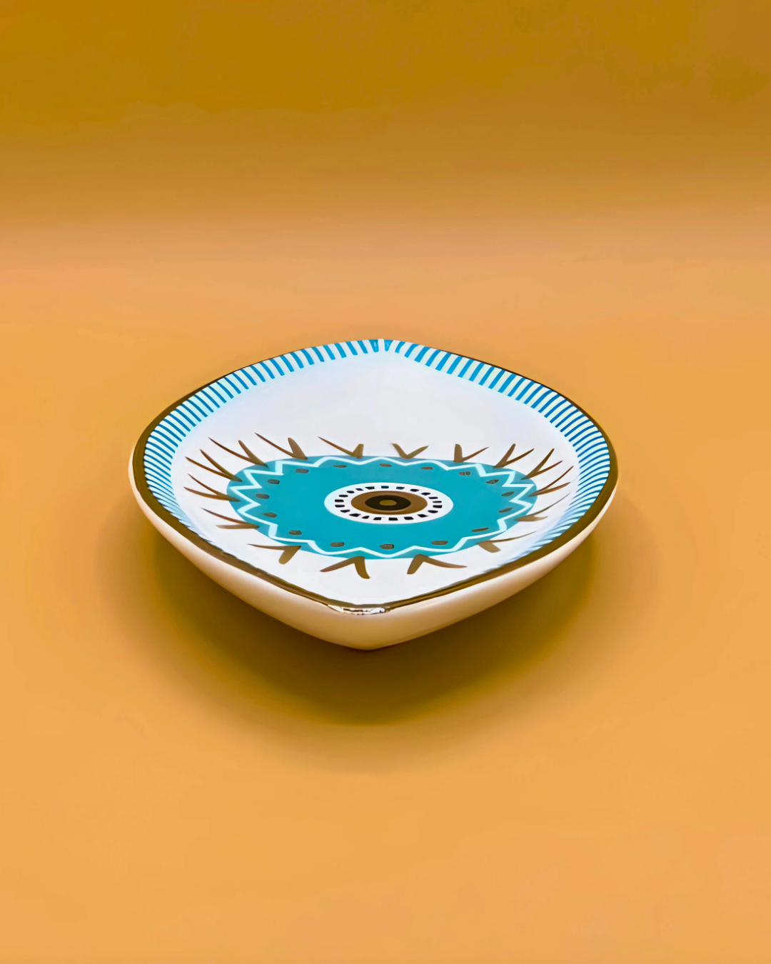 Decorative ceramic dish with blue center and white border on a yellow background