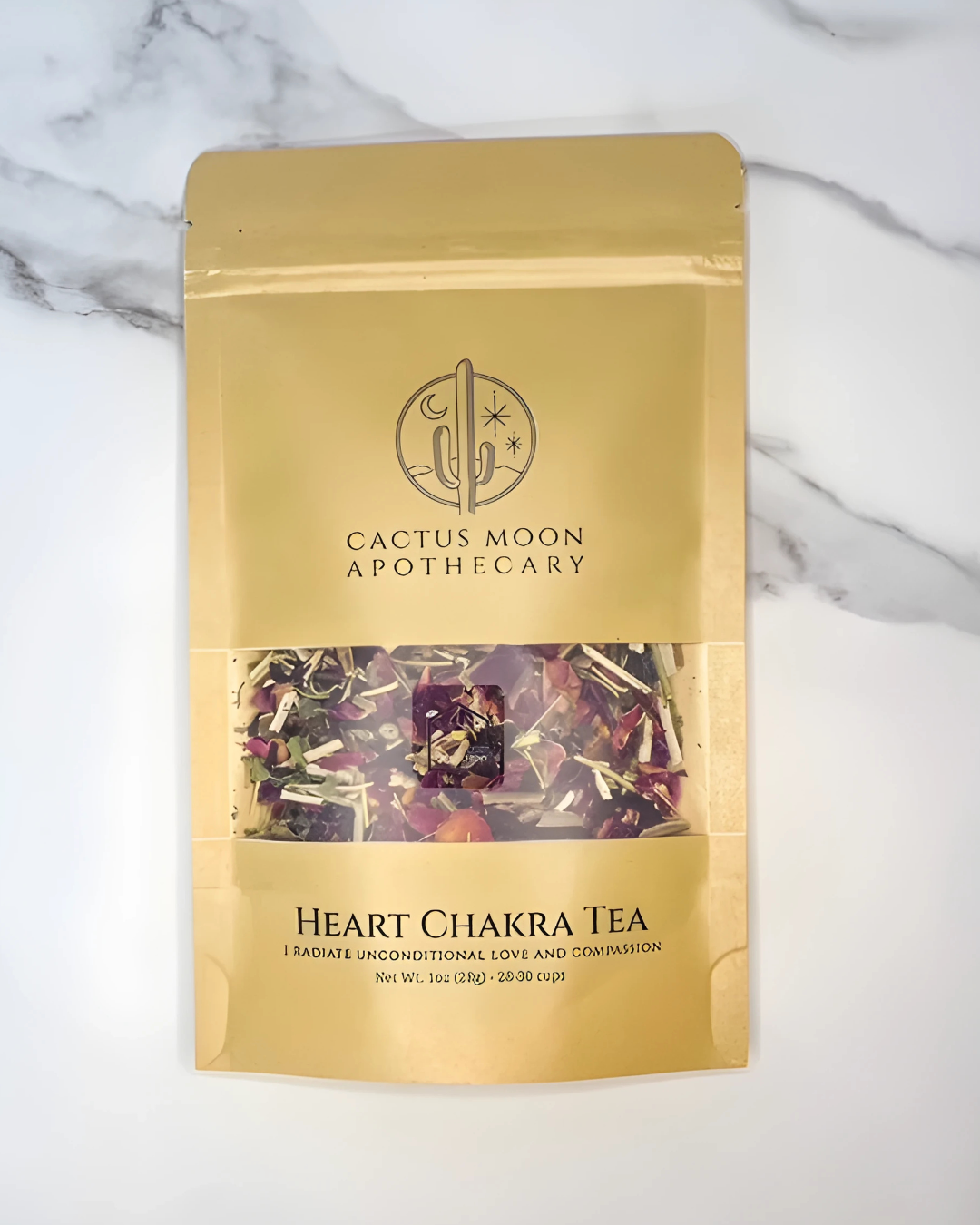 Gold packaging of Cactus Moon Apothecary Heart Chakra Tea on a marble background