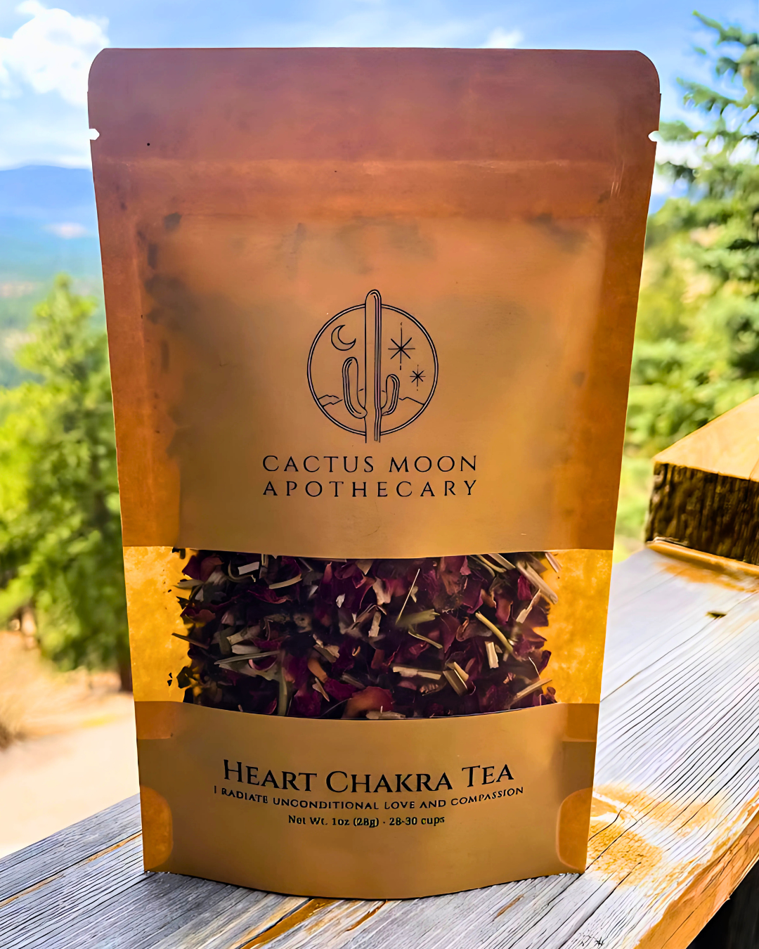 Cactus Moon Apothecary Heart Chakra Tea package on a wooden surface with a blurred natural background