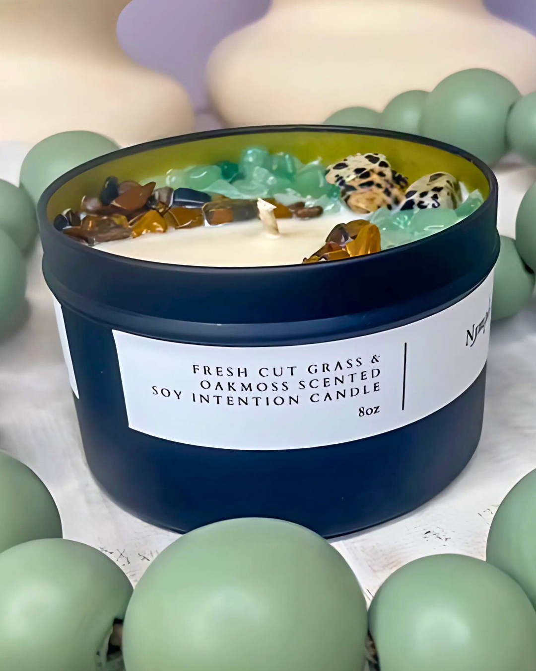 Scented candle with decorative stones and a label on a light background