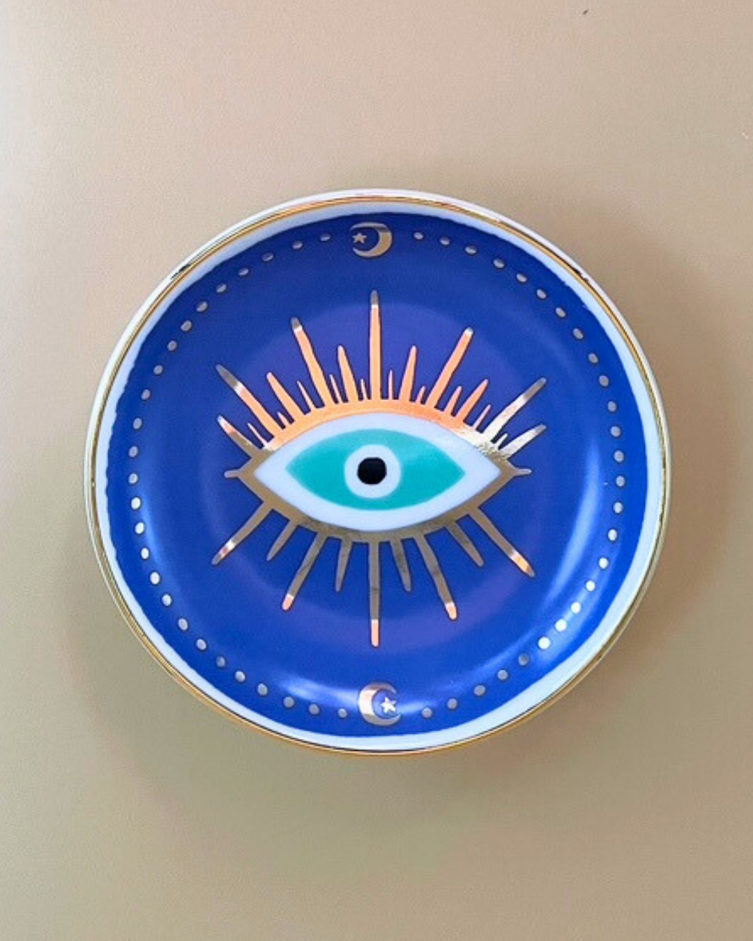 Decorative plate with eye design on a beige background