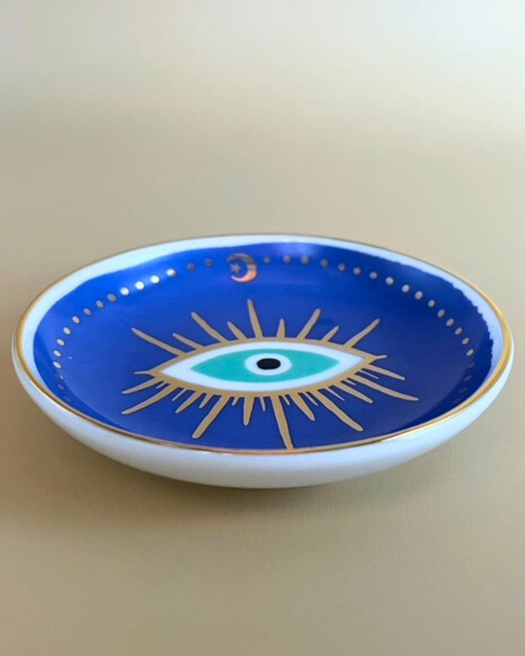 Decorative plate with an eye design on a blue background