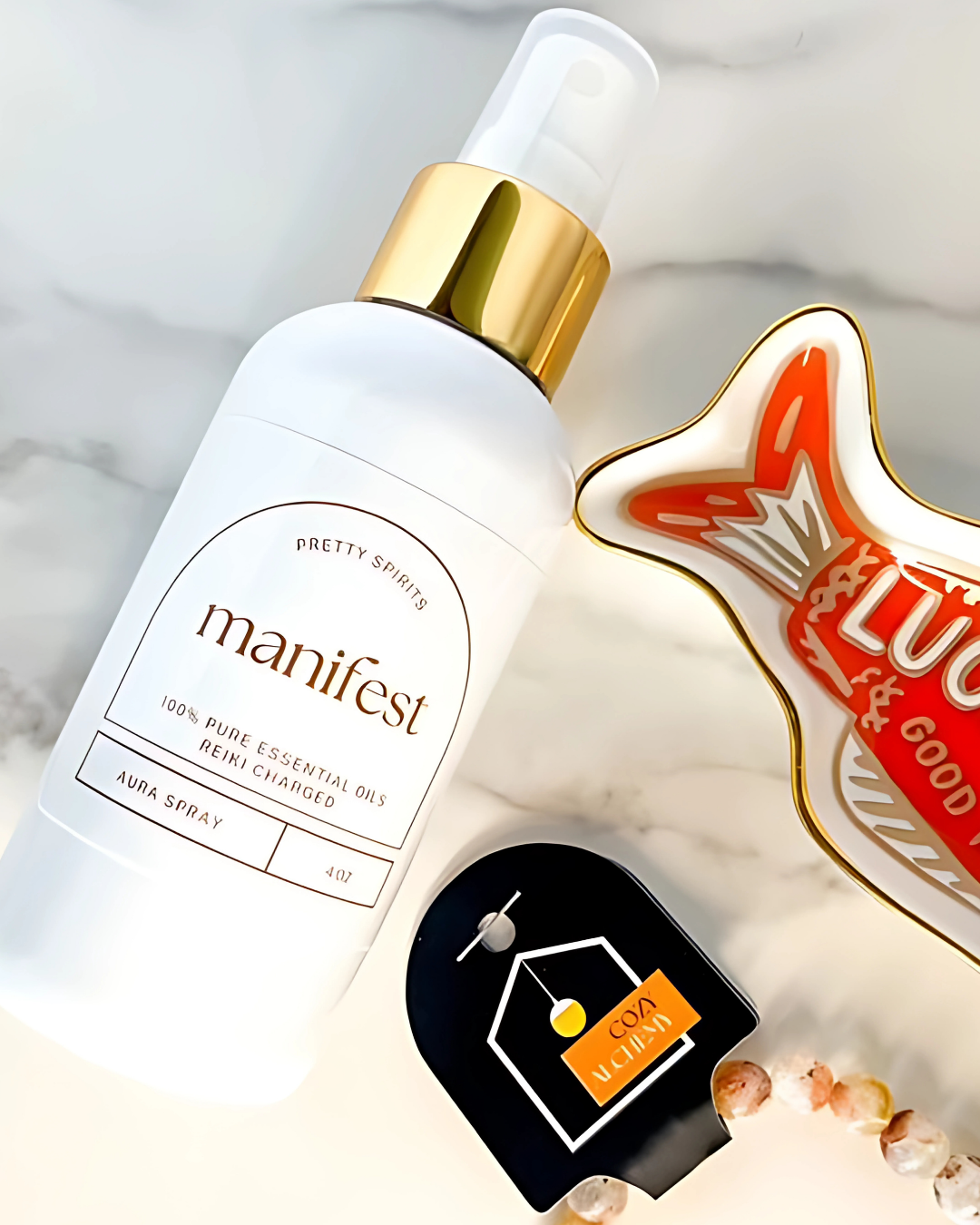 Manifest essential oil spray bottle with a gold cap on a light background