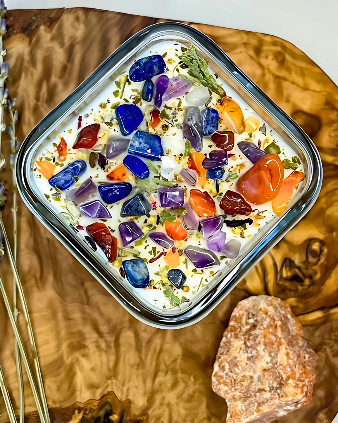Square container with colorful stones on a wooden surface