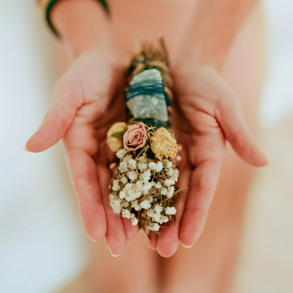 Hands holding a small bouquet of flowers with a blurred background