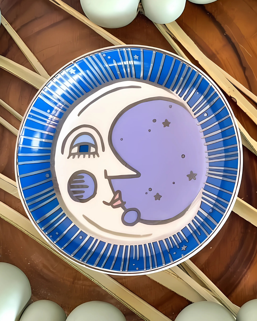 Decorative plate with a stylized face design on a wooden surface