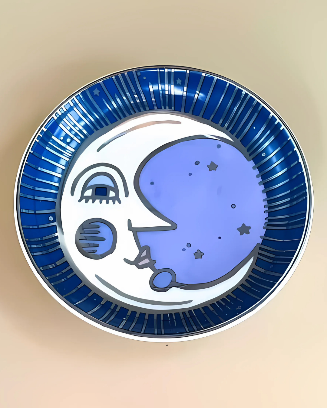 Ceramic plate with blue and white design of a face and rainbow on a beige background