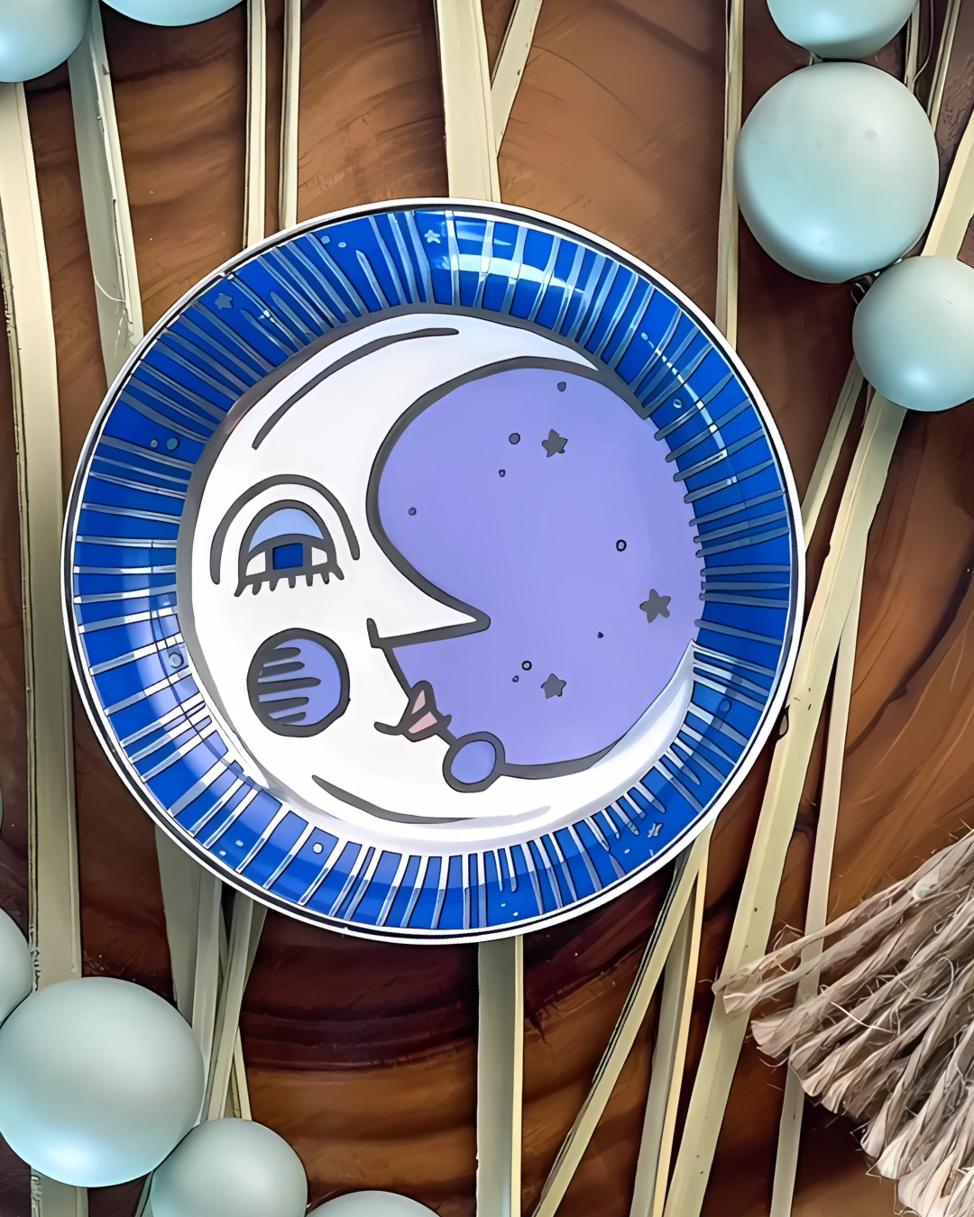Decorative plate with a moon design on a wooden surface with decorative elements.