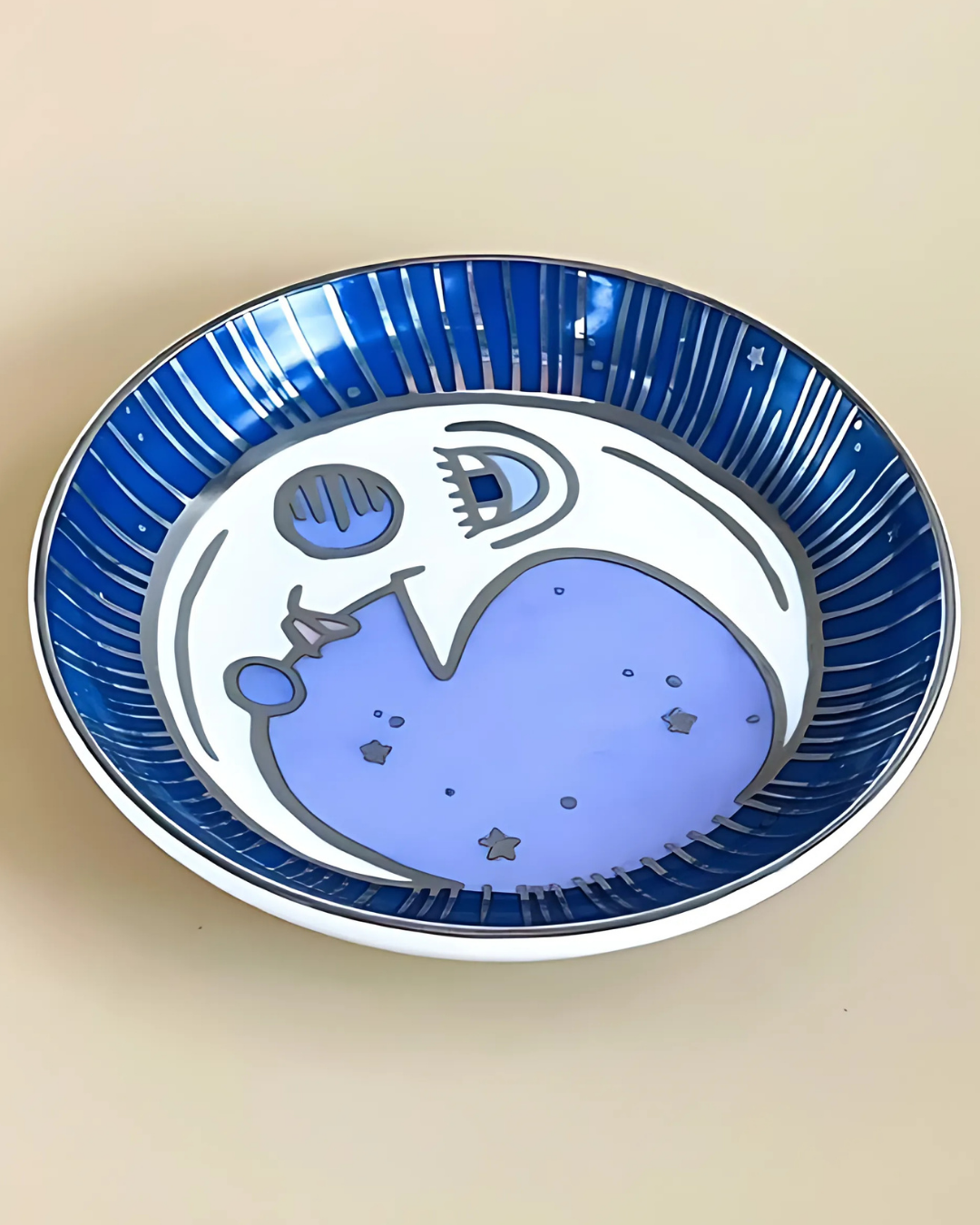 Decorative plate with blue and white abstract design on a beige background