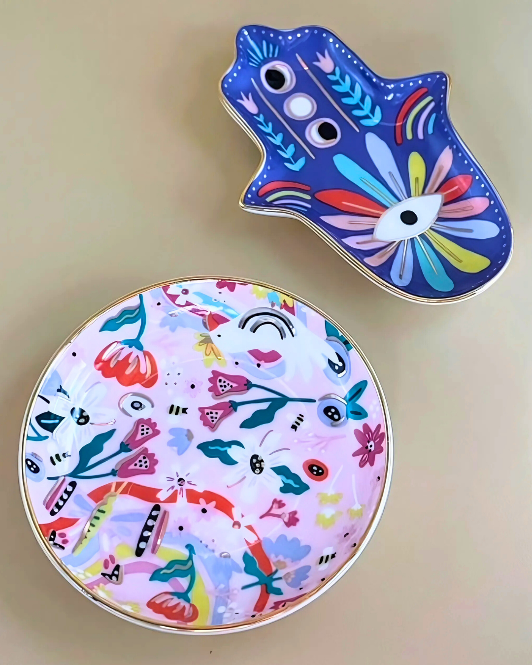 Two colorful ceramic coasters with abstract designs on a beige background