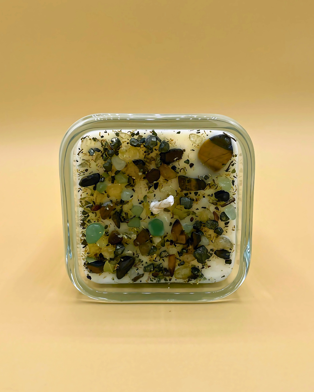 Square glass container with decorative stones on a beige background