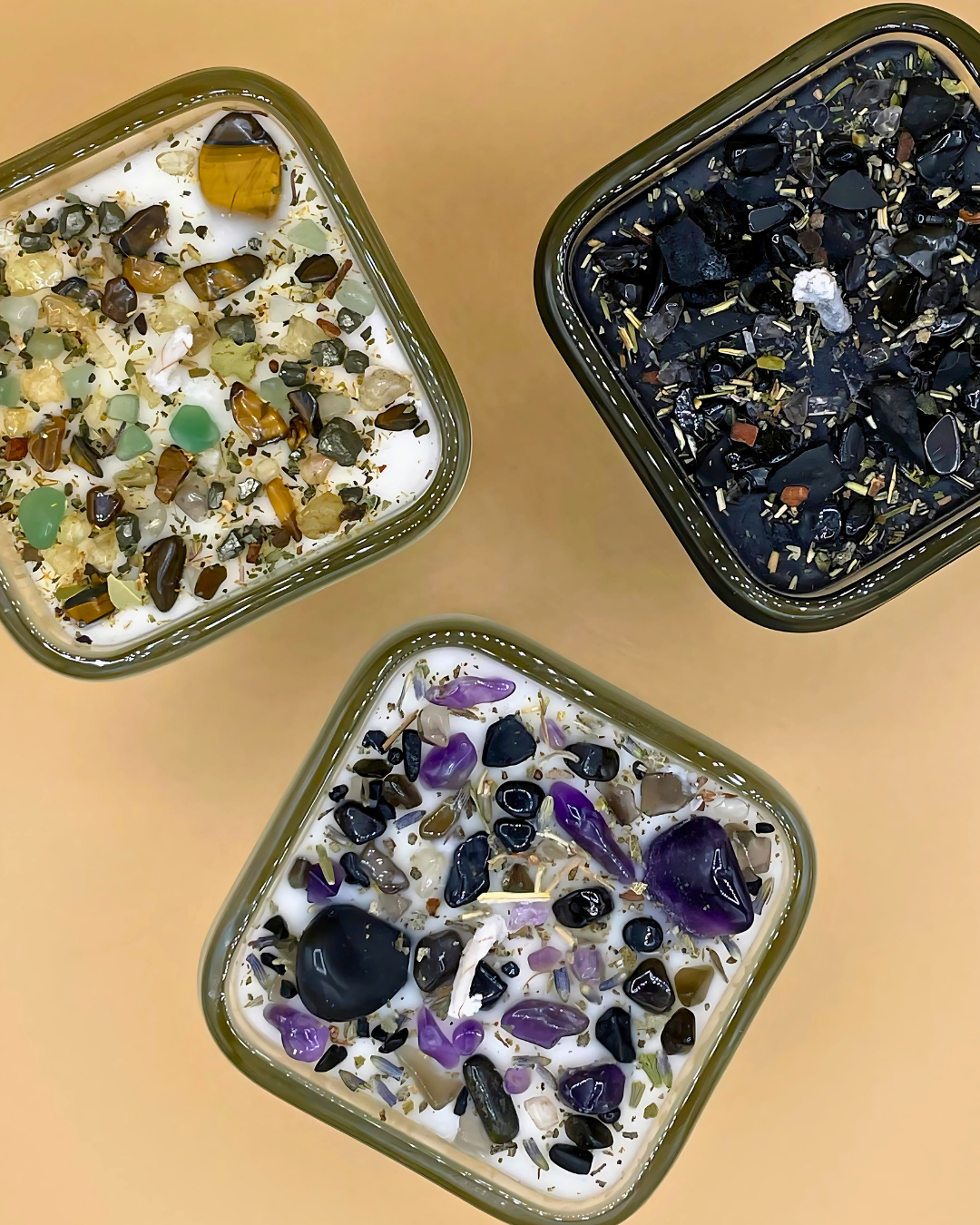 Three square containers filled with a mix of colorful stones on a beige background