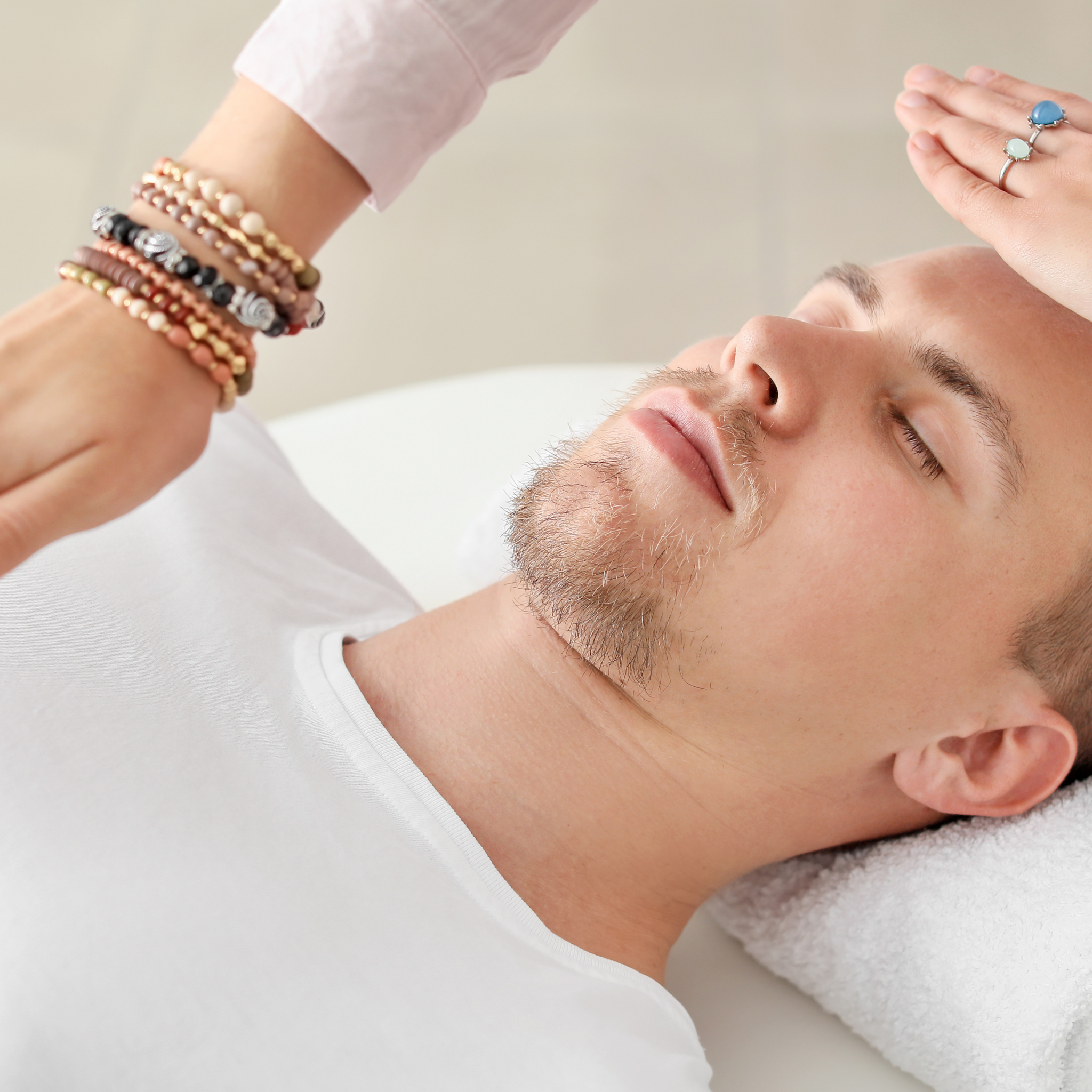 Man receiving a head massage with a neutral background