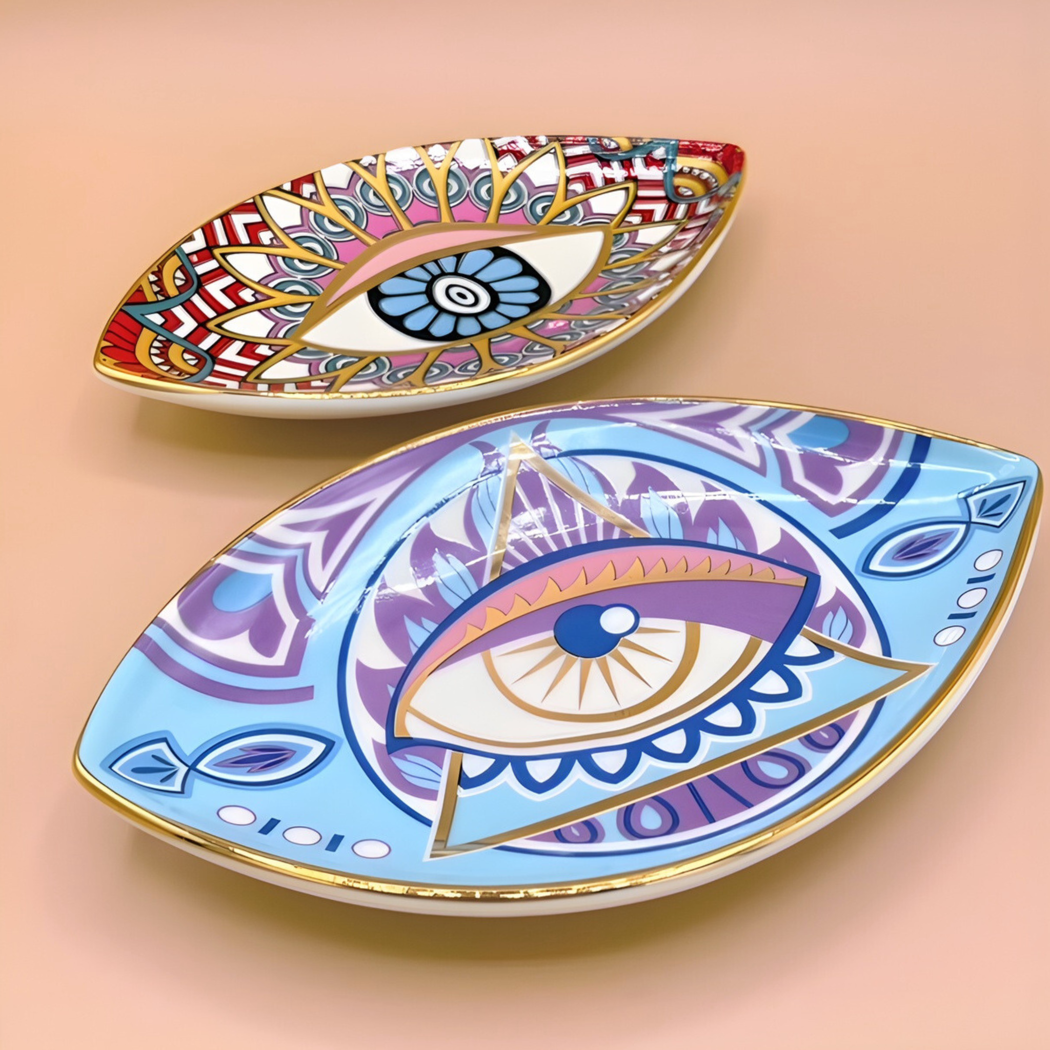 Two decorative eye-shaped plates with colorful designs on a beige background