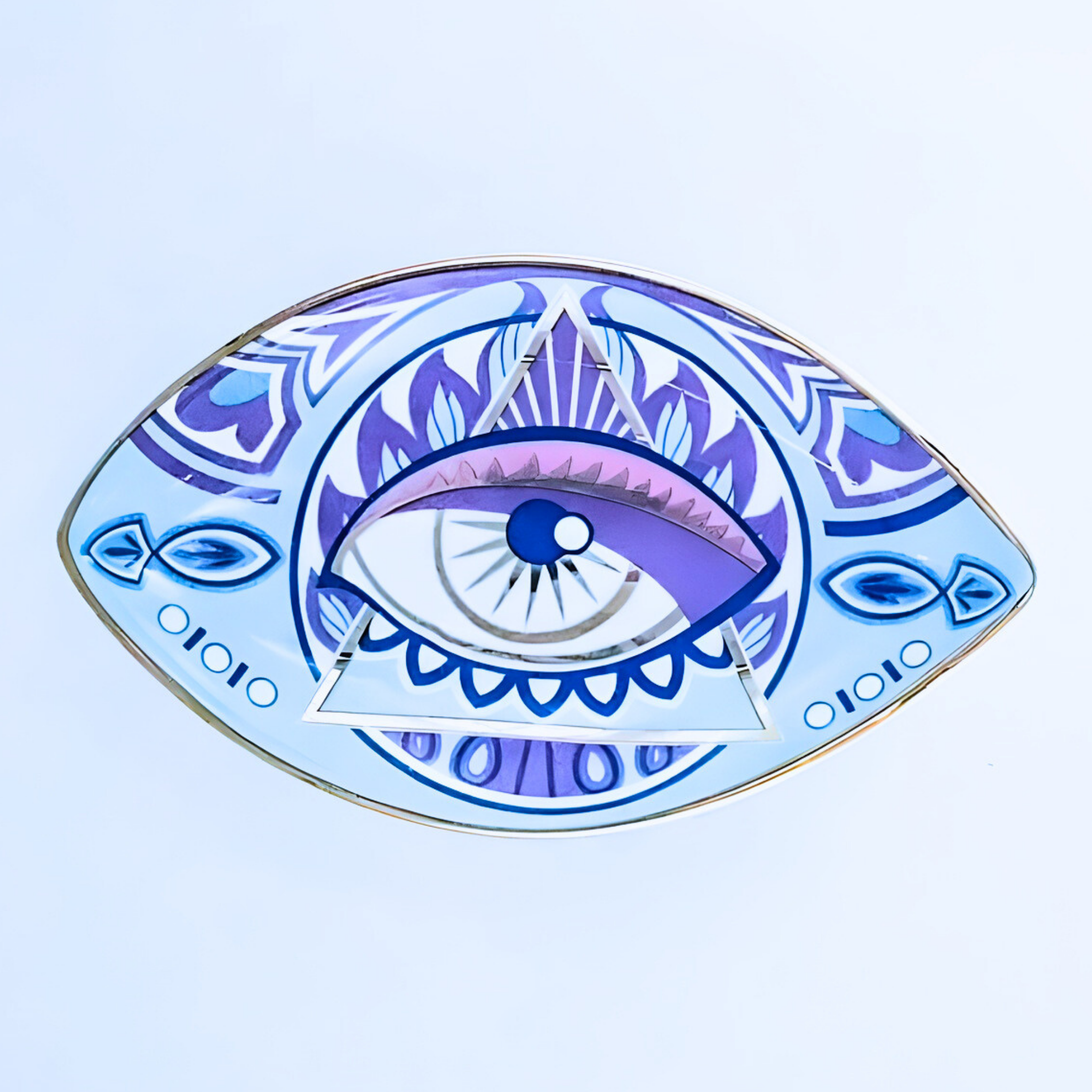 Decorative plate with eye design on a light blue background
