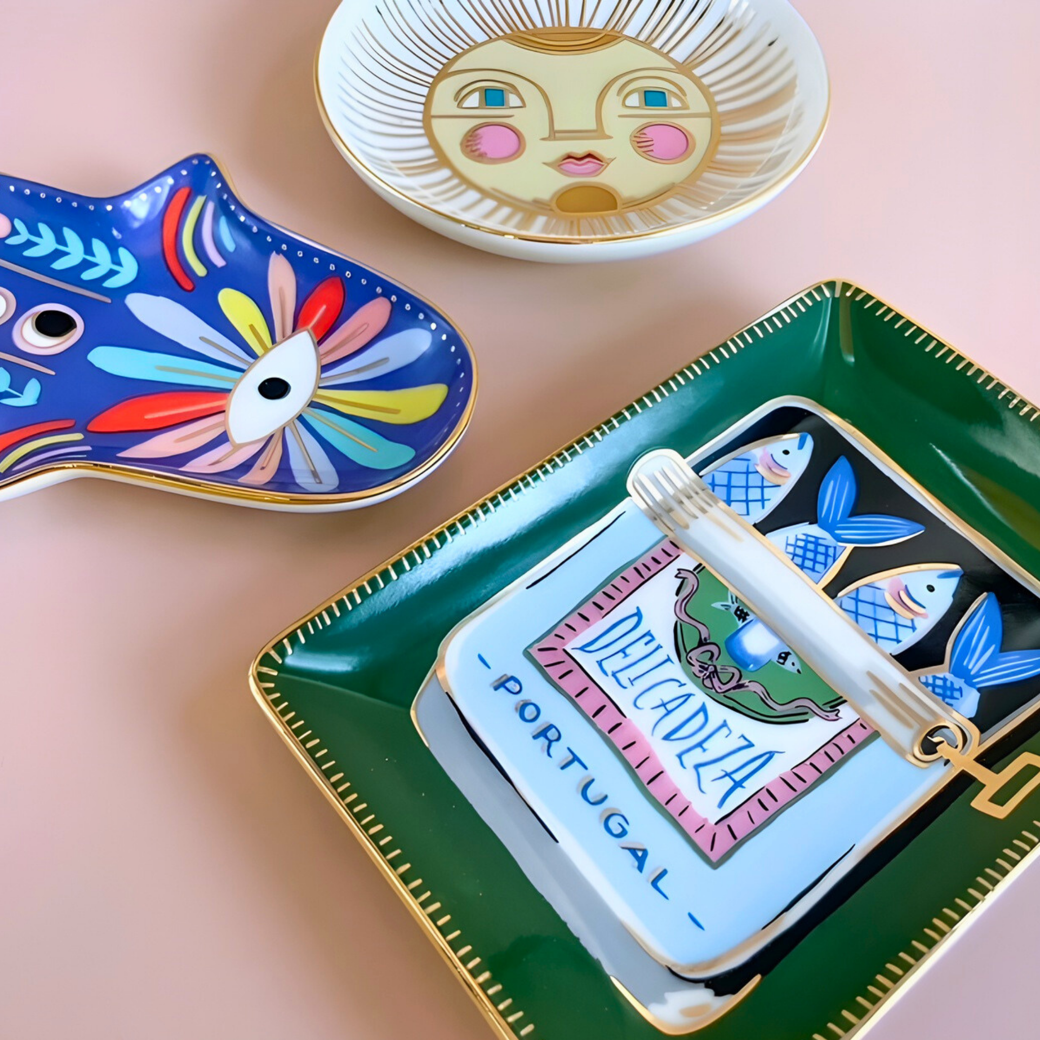Decorative trays with artistic designs on a pink surface