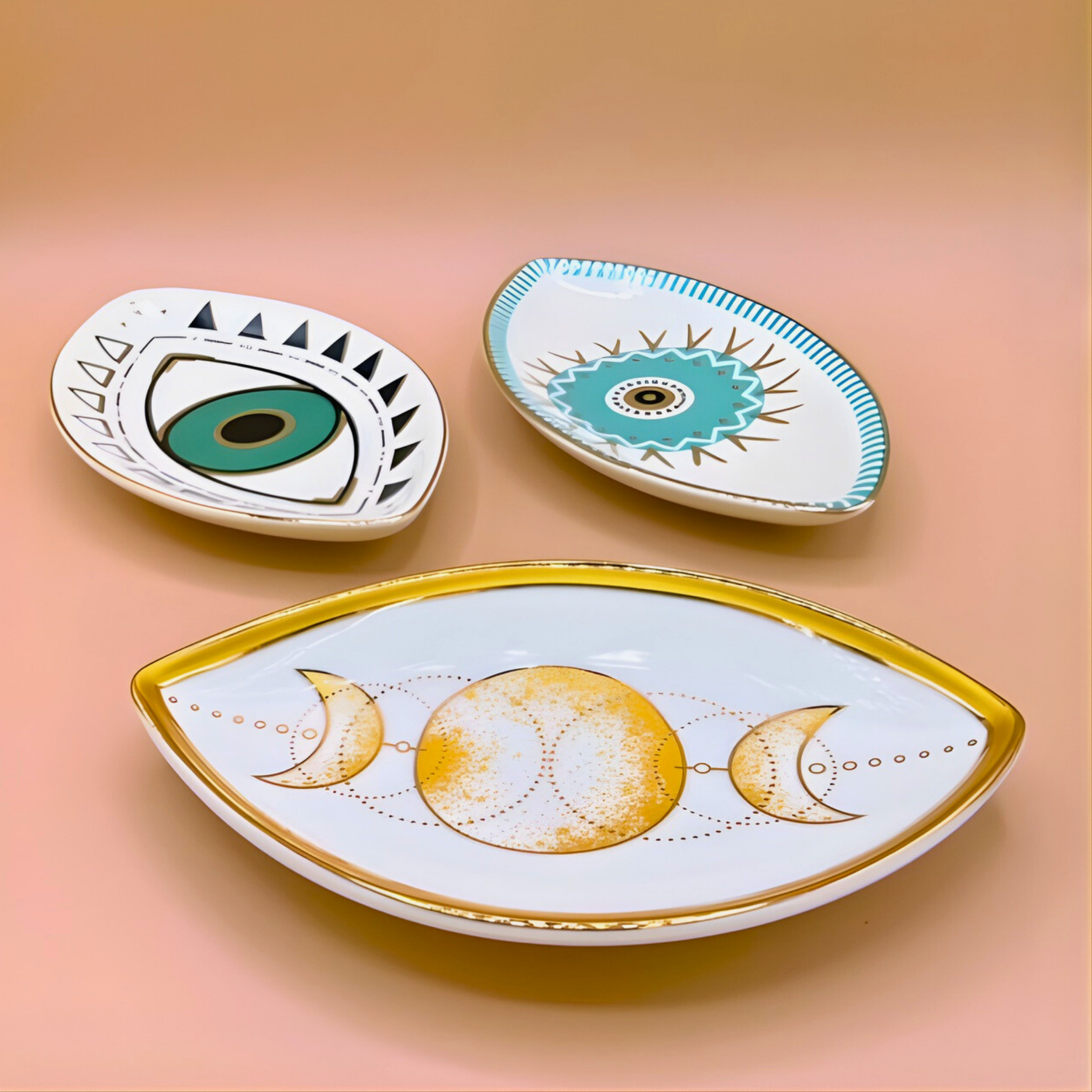 Three decorative ceramic plates with geometric designs on a peach background