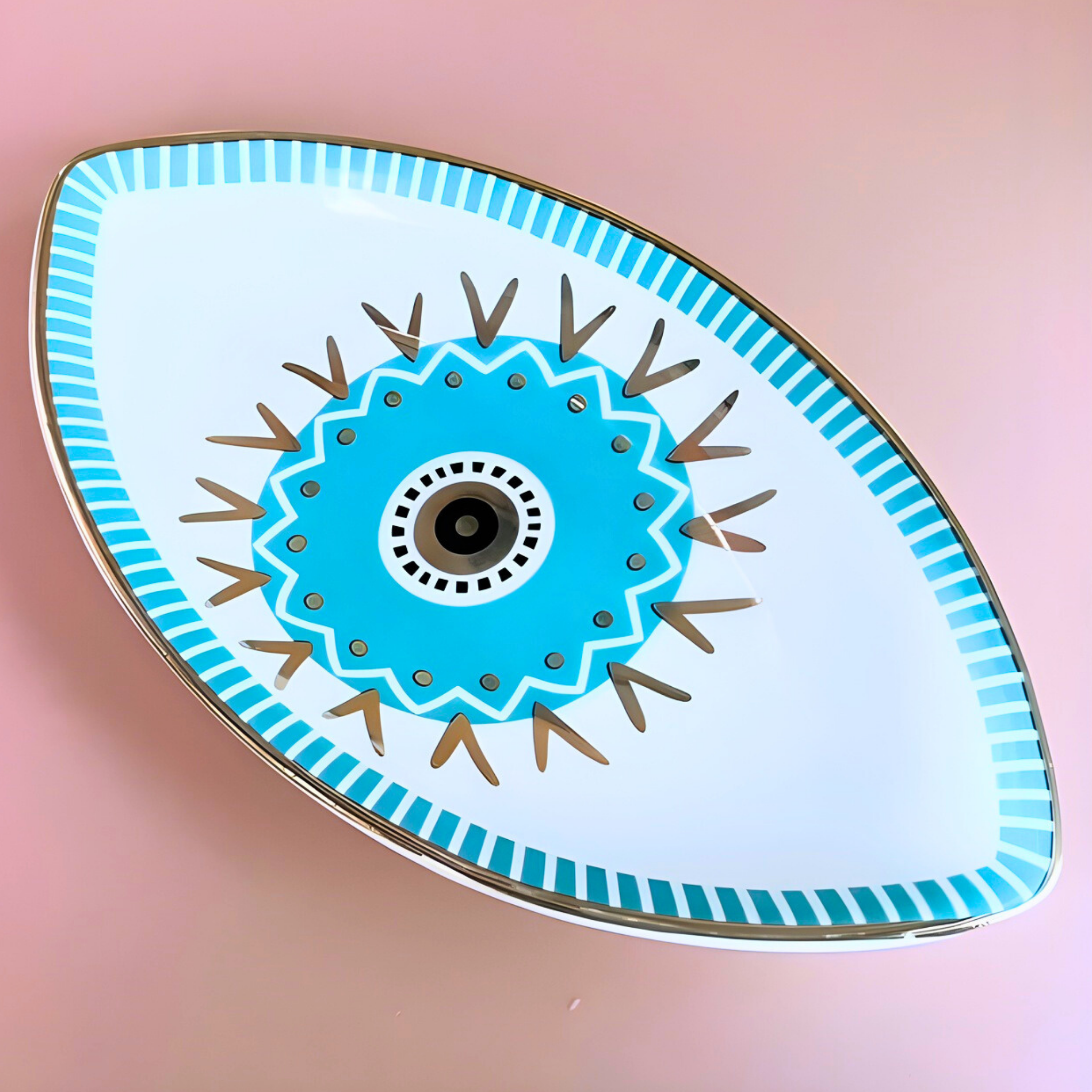 Decorative plate with blue and brown design on a pink background