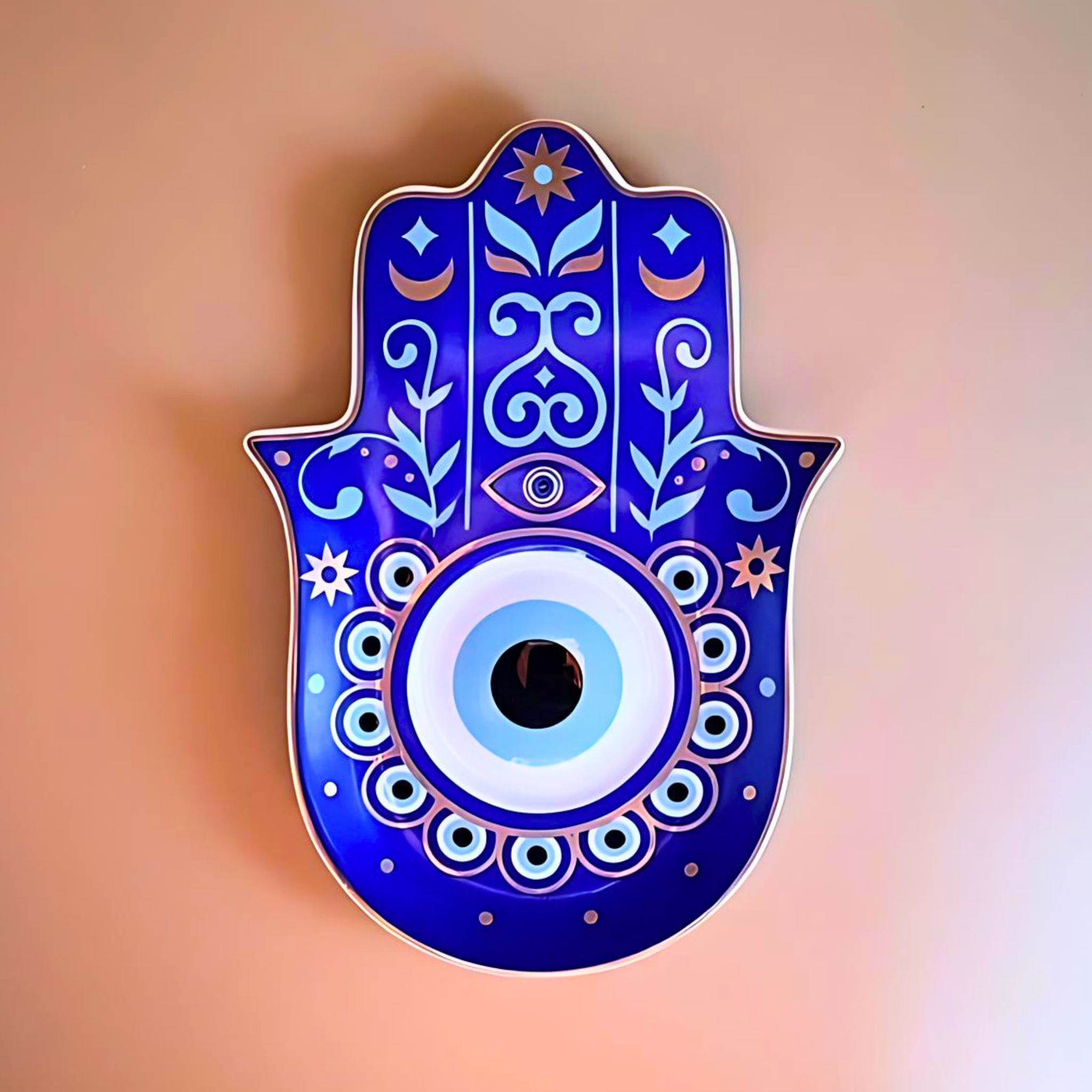 Decorative Hamsa hand with blue and white design on a peach background