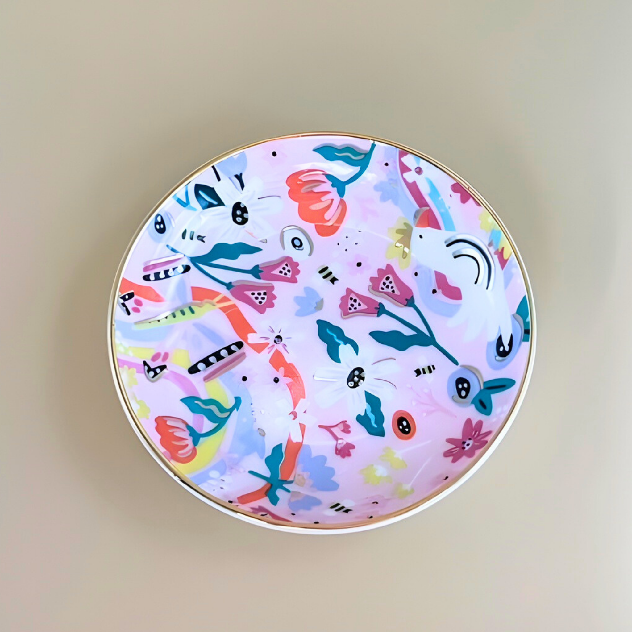 Round compact mirror with colorful floral design on a beige background
