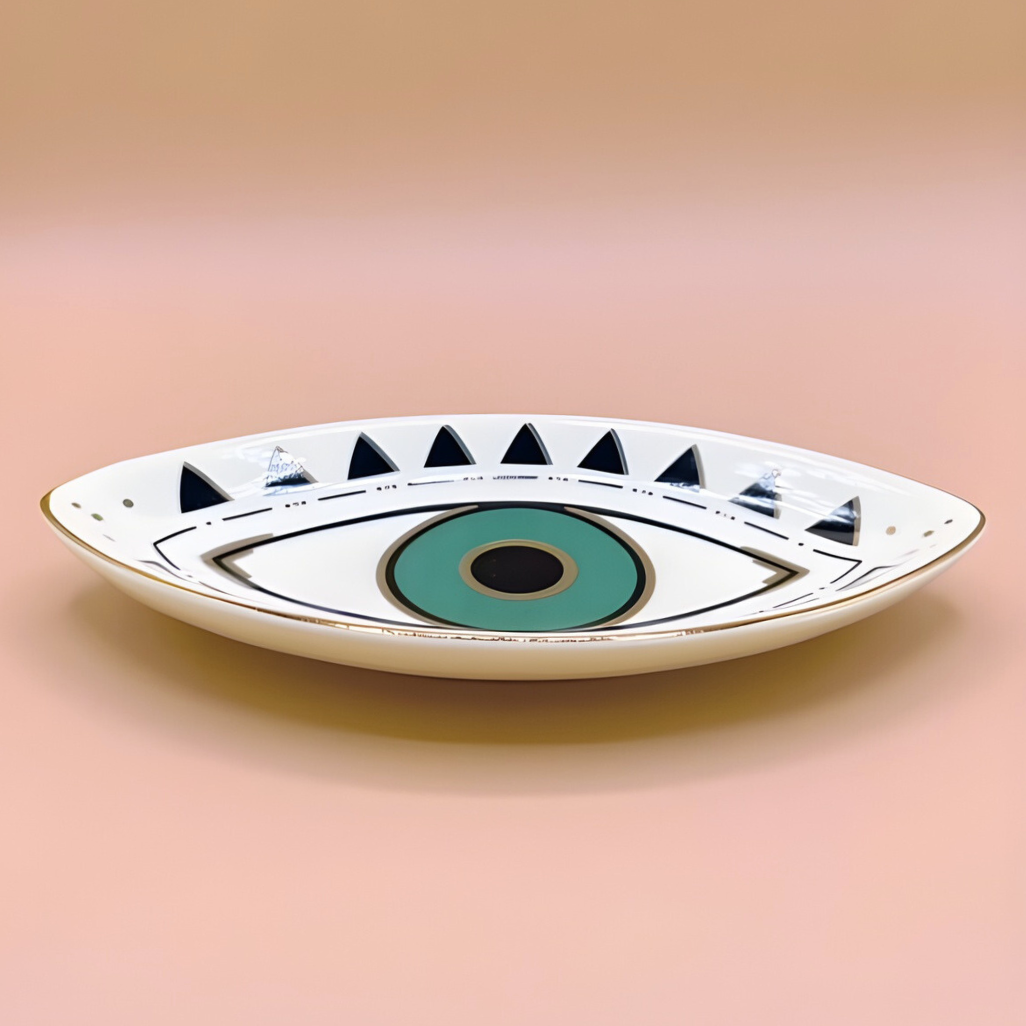 Ceramic dish shaped like an eye with a green center on a pink background