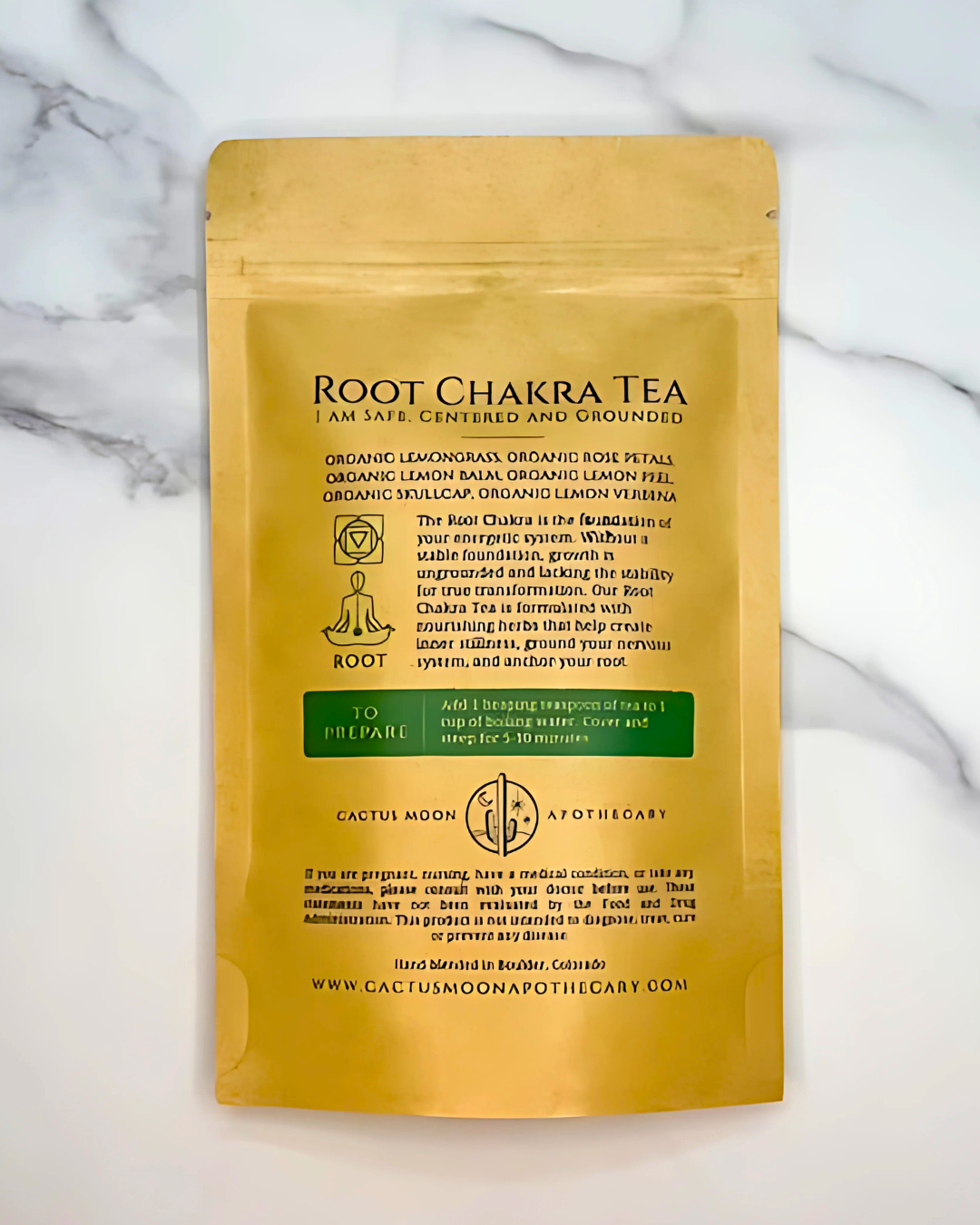 Gold package of Root Chakra Tea on a marble background