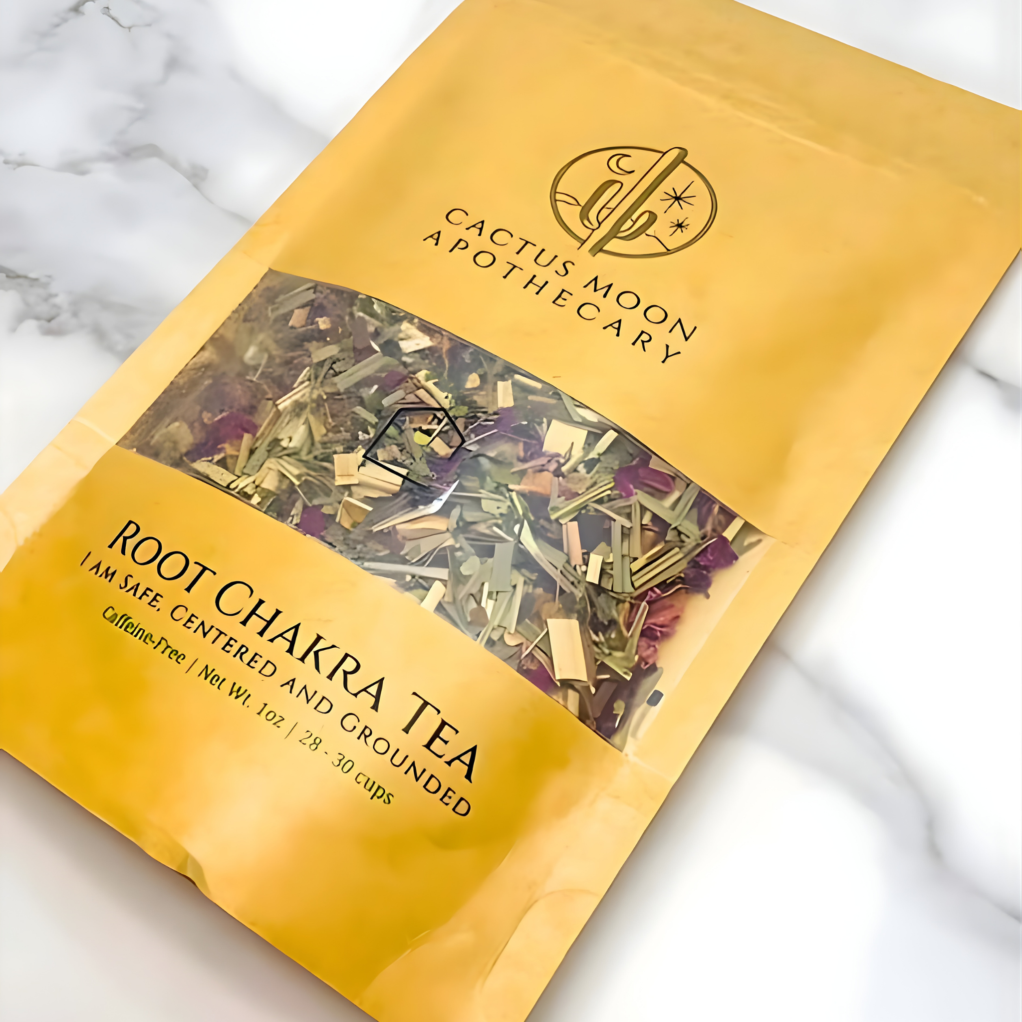 Yellow package of Root Chakra Tea from Cactus Moon Apothecary on a marble background