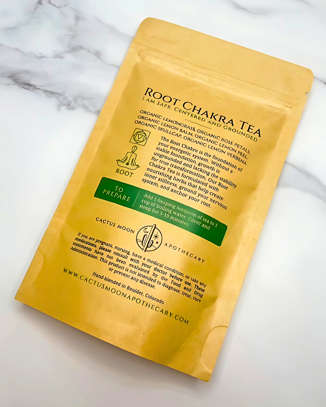 Yellow package of Root Chakra Tea on a marble surface