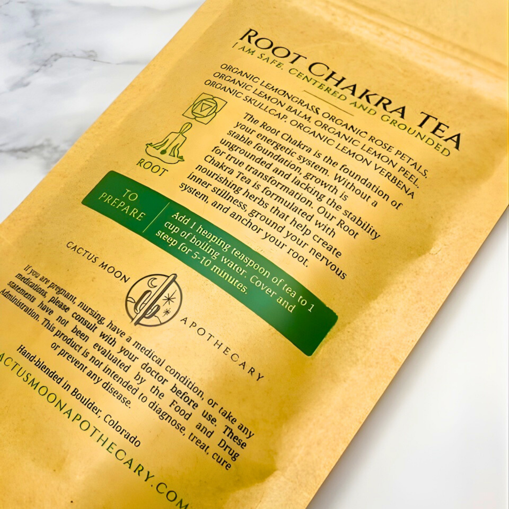 Root Chakra Tea package with text and branding on a marble surface